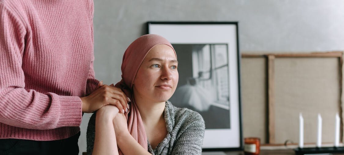 Cancer patient being comforted by a friend.